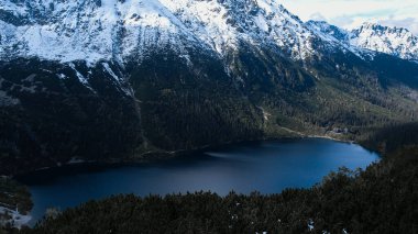 Polonya Tatry dağlarındaki Morskie Oko Karlı Dağ Kulübesi 'nin yakınındaki Kara Göl' de bulunan Çardak Staw modülü Rysamy veya Black Pond Gölü, insansız hava aracı manzarası, Zakopane, Polonya. Gökyüzü manzaralı güzel yeşil tepeler ve dağlar