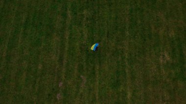 Ukrayna ulusal bayrağına sahip bir kadın, Gubalowka sıradağlarından alınan Tatra Dağları 'nın altındaki Zakopane kasabasının Vatanseverlik Havacılık görüşünü sallıyor. Drone High dağları ve yeşil tepeler yazın veya