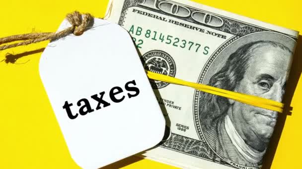 노트에 Taxes 단어가 새까만 글자로 표시되어 주변에 Banknotes — 비디오