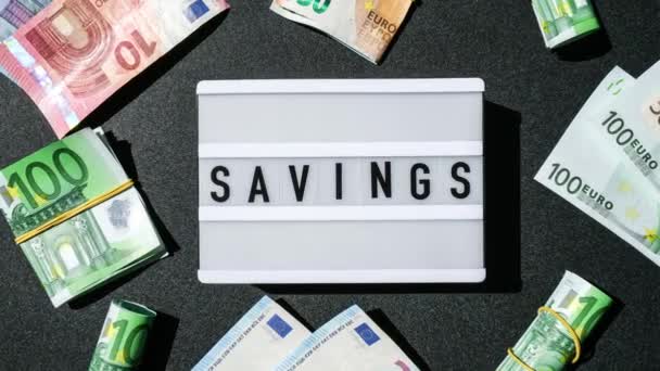 Zoom Lightbox Board Met Woord Savings Zwarte Letters Rond Eurobankbiljetten — Stockvideo