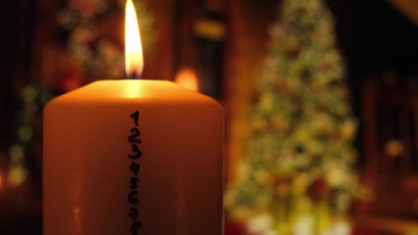 クリスマスツリーライトの装飾を背景にアドベンチャーカレンダー付きのキャンドル クリスマスのために数値を数えて伝統的な燃焼クリスマスワックスキャンドル 自宅で美しいアドベント — ストック動画