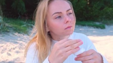 Güzel genç bir kadın, kulaklıklarına kablosuz kulaklık takıp denize bakarken gülümsüyor ve rüzgar saçlarını savuruyor. Kulaklıkla müzik dinlemek ve dans etmek. Kavram