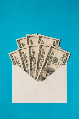 Bir dolarlık banknot, mavi arka plan fotokopi alanındaki zarfta tasarruf ediyor. Tüketim ve ekonomi para topluyor. Bahşiş. İş, finans, tasarruf, bankacılık ve insan konsepti. Ekstra para, pasif