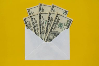 Bir dolarlık banknot, sarı arka plan fotokopi alanındaki zarf içinde tasarruf ediyor. Tüketim ve ekonomi para topluyor. Bahşiş. İş, finans, tasarruf, bankacılık ve insan konsepti. Ekstra para, pasif