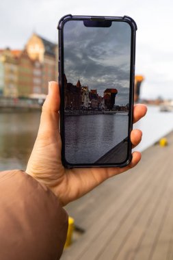 Gezgin, Gdansk 'taki Eski Zuraw Kasabası' nın fotoğrafını çekiyor. Moltawa Nehri 'ndeki Granary Adası yansıması. Gdansk Polonya 'yı ziyaret edin. Birlikte turistik eğlence blogcusu