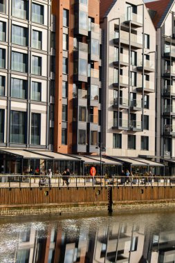 Old Town 'daki Motlawa Nehri üzerindeki modern binalar. Soyut yapı. Motlawa Nehri 'nde yaratıcı fotoğraf turizmi. Granary Adası cam pencerelerinde yansımalı yeni apartmanlar mimarisi