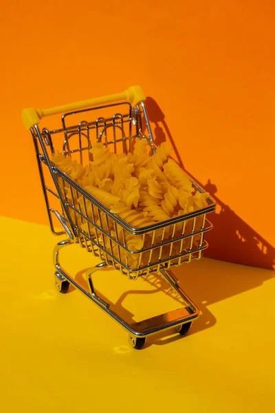 Wózek Sklepowy Wypełniony Makaronem Kolorowym Żółtym Pomarańczowym Tle Izometrycznym Skopiuj — Zdjęcie stockowe