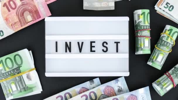 Zoom Out Lightbox Board Com Palavra Invest Letras Pretas Torno — Vídeo de Stock