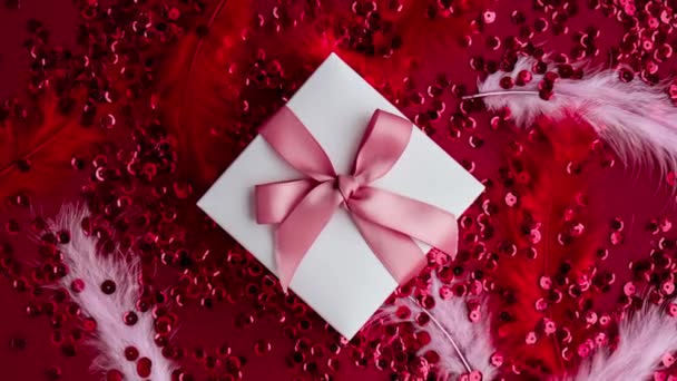 Увеличить Подарочную Коробку Розовой Лентой Красном Блестящем Конфетти Блестящими Фоне — стоковое видео