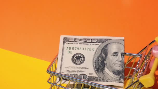 Sarı Arka Planda Alışveriş Arabasında 100 Dolarlık Banknotla Oyuncak Süpermarket — Stok video