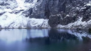 Polonya Tatry dağlarındaki Morskie Oko Karlı Dağ Kulübesi 'nin yakınındaki Kara Göl' de bulunan Çardak Staw modülü Rysamy veya Black Pond Gölü, insansız hava aracı manzarası, Zakopane, Polonya. Gökyüzü manzaralı güzel yeşil tepeler ve dağlar