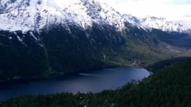 Polonya Tatry dağlarındaki Morskie Oko Karlı Dağ Kulübesi 'nin yakınındaki Kara Göl' de bulunan Çardak Staw modülü Rysamy veya Black Pond Gölü, insansız hava aracı manzarası, Zakopane, Polonya. Gökyüzü manzaralı güzel yeşil tepeler ve dağlar