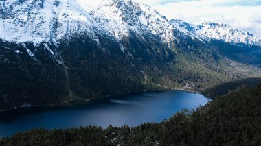 Polonya Tatry dağlarındaki Morskie Oko Karlı Dağ Kulübesi 'nin yakınındaki Kara Göl' de bulunan Çardak Staw modülü Rysamy veya Black Pond Gölü, insansız hava aracı manzarası, Zakopane, Polonya. Gökyüzü manzaralı güzel yeşil tepeler ve dağlar