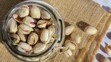 4k zoom in out Pistachios in burlap sack on concrete table. Organic pistachios. Vegan Healthy food high protein. Dietary nutrition. Concept of nuts omega vitamin