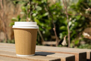 Eko-geridönüşüm kağıt bardağı, kahve ya da ahşap masadaki kraft kağıdına çay ile. Sokakta, parkta, bankta kahvaltı. Kahveyi paket yap. Uzayı metin için kopyala. Tek kullanımlık karton kahve.