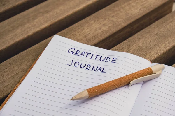 Writing Gratitude Journal on wooden bench. Today I am grateful for. Self discovery journal, self reflection creative writing, self growth personal development concept. Self care wellbeing spiritual health, being mindful, holistic health practices hab