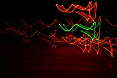 Long exposure, light painting photography, multi color swirl effect against black background. Night city lights. Creative background wallpaper