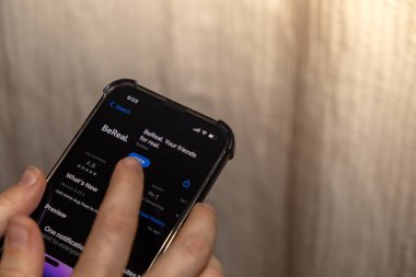 Gdansk Polonya - Ekim 2022. iPhone ekranında BeReal sosyal medya uygulamalı akıllı telefonu olan bir kız. BeReal, Time to Be Real için popülerliğini arttıran bir Fransız sosyal medya uygulaması.