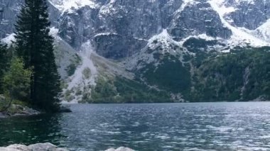 Tatra National Park, Poland. Famous Mountains Lake Morskie Oko Or Sea Eye Lake In autumn. Snow covered mountain peaks on background. Blue water nature landscape 4k