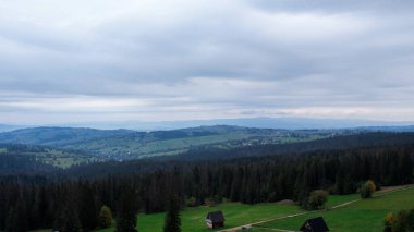 Tatra Dağları 'nın altındaki Zakopane kasabasının havadan görünüşü Gubalowka sıradağlarından alındı. Drone High dağları ve yeşil tepeler yazın veya ilkbaharda. Polonya 'da manzaralı dağ manzarası. Seyahat