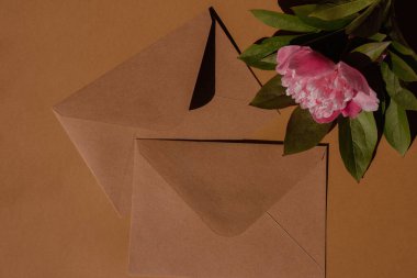 Greeting or invitation card mockup with envelope Blank paper card with copy space, peony flower with sunlight shadows. Top view, flat lay minimalist aesthetic luxury bohemian business branding concept