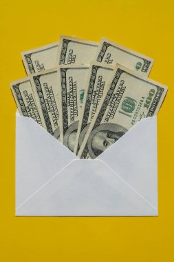 Dollar banknote saving money in envelope on yellow background copy space. Consumption and economy Collecting money. Tips. Business, finance, saving, banking and people concept. Extra money, passive income. Saving for travel, crisis, house, car, educa