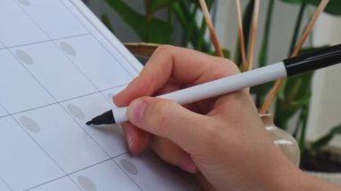 Female hand writing word SELF CARE with marker on Monthly PLANNER. Making appointment of event holiday Magnetic board with the days of the month. Place to enter important matters schedule. Whiteboard