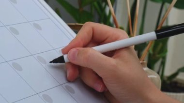 Female hand writing word START DIET with marker on Monthly PLANNER. Making appointment of event holiday Magnetic board with the days of the month. Place to enter important matters schedule. Whiteboard