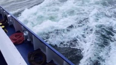 Geminin uyanması. Tekneden geniş bir iz var. Okyanus suyu. Koyu mavi. Büyük gemiden izler. Lüks yelkenli yattan günbatımı ışınları. Denizde gemi gezisi. Sürat teknesinin arkasından gelen dalgalar