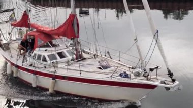 Gdansk, Poland - May 2022 Man resting on sailing private ship against Gdansk Poland city. Man is driving the yacht at sunset Old town touristic destination 