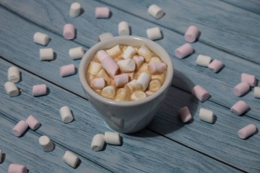 Close up of Cup hot chocolate marshmallows cacao. Cozy Coffee with marshmallows on wooden blue background. Copy space for text. Wallpaper design. Sweet unhealthy food 