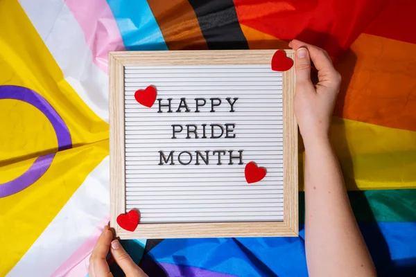 HAPPY PRIDE MONTH frame on Rainbow LGBTQIA flag made from silk material. Symbol of LGBTQ pride month. Equal rights. Peace and freedom. Support LGBTQIA community. Diversity equality