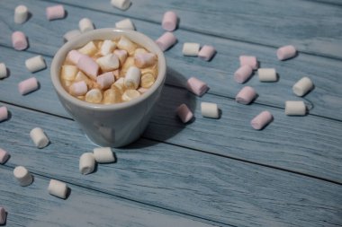 Close up of Cup hot chocolate marshmallows cacao. Cozy Coffee with marshmallows on wooden blue background. Copy space for text. Wallpaper design. Sweet unhealthy food 