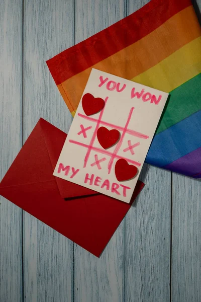 Handmade valentine with Text YOU WON MY HEART and tic tac toe game red envelope and LGBTQ flag. Gift idea with your own hands. Diversity equality