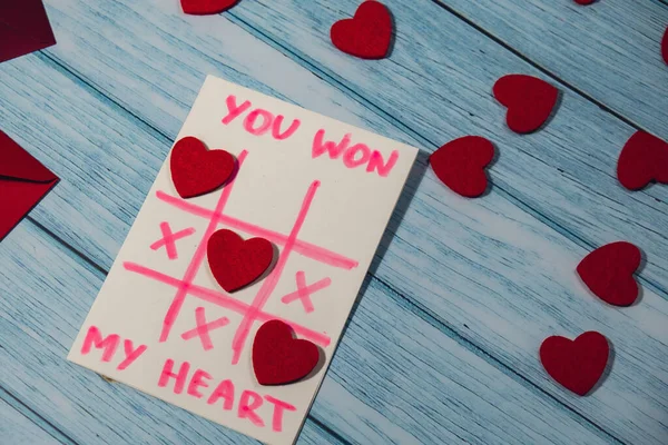 Valentines Day. Text YOU WON MY HEART and tic tac toe game Postcard craft, greeting card. DIY Step by step instruction. Making of handmade Valentine greeting card hobby concept, gift with your own hands.