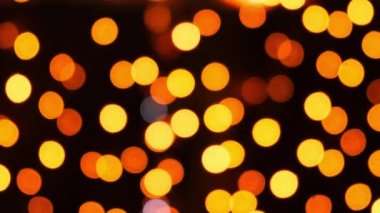 Defocused pulsating colorful lights bokeh against dark background. Abstract bokeh holiday background. Presentation Party Bokeh Effect. Yellow and orange Christmas and New Year colors