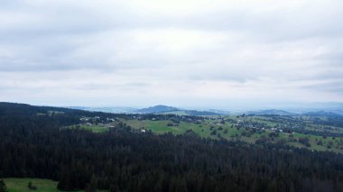 Aerial view of Zakopane town underneath Tatra Mountains taken from the Gubalowka mountain range. Drone High mountains and green hills in summer or spring. Scenic mountain view in Poland. Travel tourist destinations