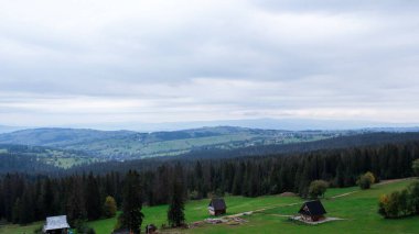 Aerial view of Zakopane town underneath Tatra Mountains taken from the Gubalowka mountain range. Drone High mountains and green hills in summer or spring. Scenic mountain view in Poland. Travel tourist destinations