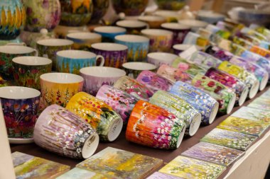 Gdansk, Poland - 9 August 2022 Polish culture - showcase with folk products on the street market. Hand painted mugs. Dominic's Fair in Gdansk Colorful collection of mugs on the counter of gift shop in Gdansk. Souvenir market. Tourist travel attractio