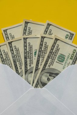 Dollar banknote saving money in envelope on yellow background copy space. Consumption and economy Collecting money. Tips. Business, finance, saving, banking and people concept. Extra money, passive income. Saving for travel, crisis, house, car, educa