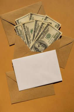 Dollar banknote saving money in envelope on beige background copy space. Consumption and economy Collecting money. Tips. Business, finance, saving, banking and people concept. Extra money, passive income. Saving for travel, crisis, house, car, educat