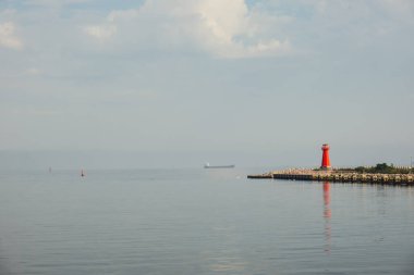 Mavi deniz hattındaki deniz feneri. Baltık Denizi 'nde güneşli bir günde dalgalar. Gdansk Polonya. Gemiden fenere yüzmek. Deniz suyu arka planı
