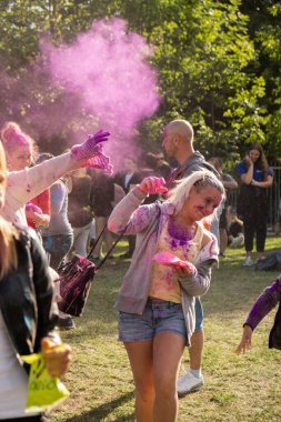 Gdansk, Polonya - Ağustos 2022. Holi Festivali Kutlamaları Mutlu gençlerden oluşan bir kalabalık renk festivali sırasında renkli Holi tozları atan insanların eğlencesine katılıyor. Dışarıda eğleniyoruz. 