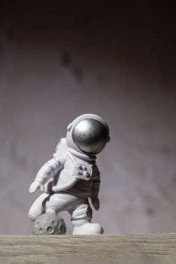 Plastic toy figure astronaut on moon concrete background Copy space. Concept of out of earth travel, private spaceman commercial flights. Space missions and Sustainability