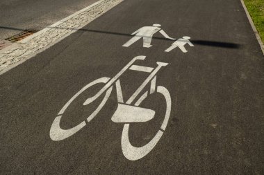 Cyclist and pedestrian route zone on a street. Painted Street Asphalt Bicycle Lane Sign White Safety sharing sign. Road sign Pedestrian and bicycle can cross the street here on the background of blue