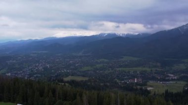 Tatra Dağları 'nın altındaki Zakopane kasabasının havadan görünüşü Gubalowka sıradağlarından alındı. Drone High dağları ve yeşil tepeler yazın veya ilkbaharda. Polonya 'da manzaralı dağ manzarası. Seyahat