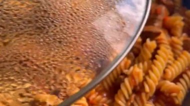 Cooking Pasta In Pan Boiling Food. Delicious Italian Bolognese spices and minced meat. Homemade hot, steamy pasta. Heating pasta with meat in frying pan. 