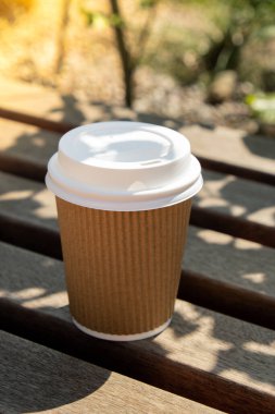 Eko-geridönüşüm kağıt bardağı, kahve ya da ahşap masadaki kraft kağıdına çay ile. Sokakta, parkta, bankta kahvaltı. Kahveyi paket yap. Uzayı metin için kopyala. Tek kullanımlık karton kahve.