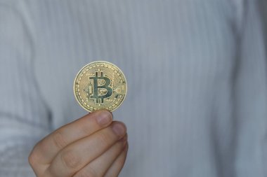 Female hands holding Bitcoin gold coin. Bitcoin mining trading concept. BTC golden money spinning around. Worldwide virtual internet Cryptocurrency or crypto digital payment system. Digital coin money