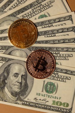 Bitcoin gold coin on bills of 100 dollars American currency. Bitcoin mining trading concept. BTC golden money. Worldwide virtual internet Cryptocurrency or crypto digital payment system. Digital coin